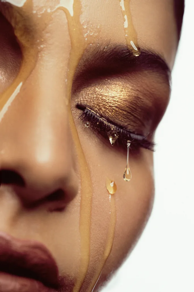 Beauty close-up with honey dripping over gold eye makeup, photographed by Shreyak Singh
