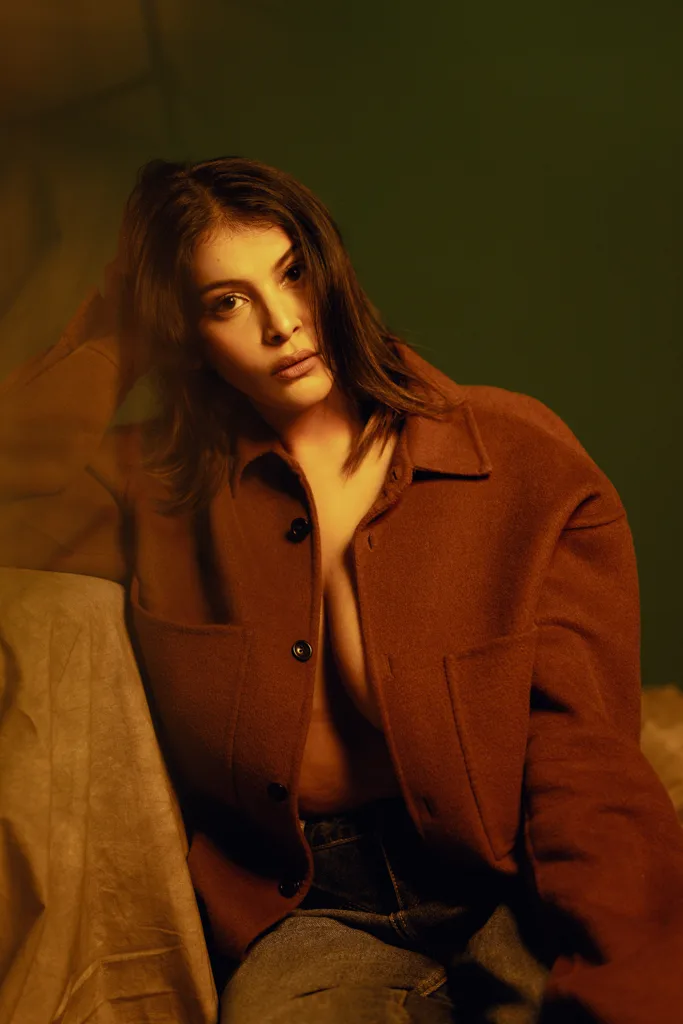 Fashion portrait in a brown overshirt against a green backdrop, photographed by Shreyak Singh