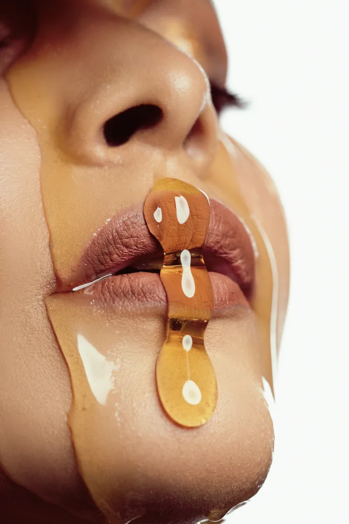 Beauty close-up with honey dripping over the lips, photographed by Shreyak Singh