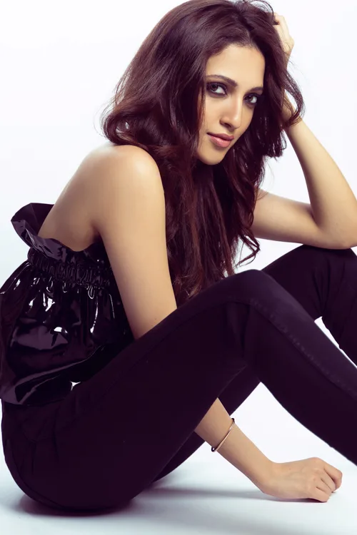 Fashion photograph, model seated on the floor in a black outfit, photographed by Shreyak Singh