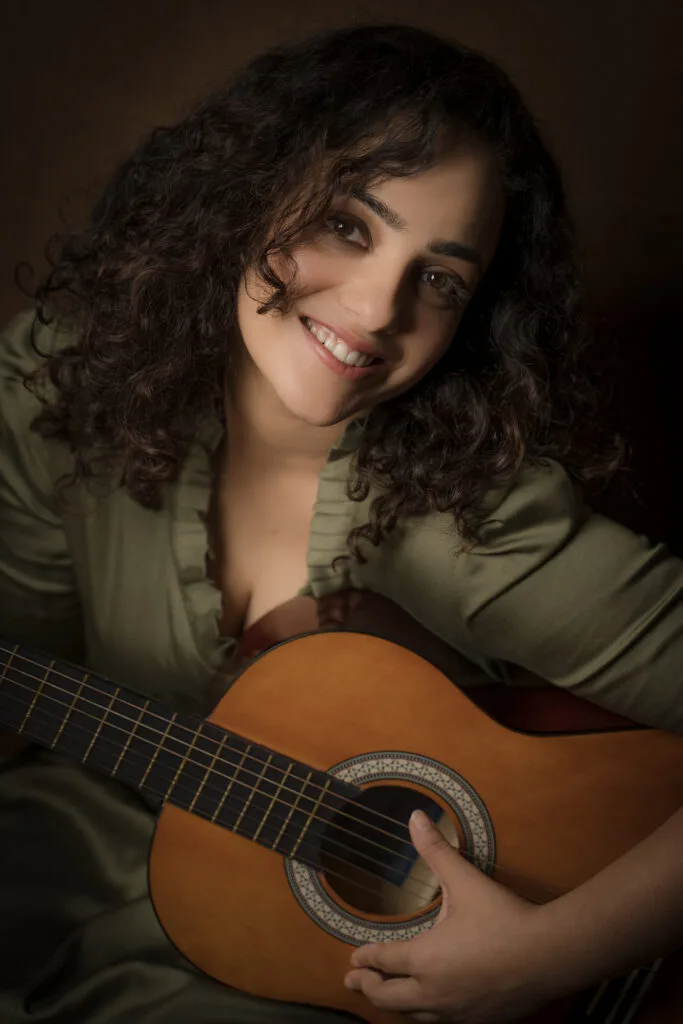 Portrait of a musician with an acoustic guitar in green light, photographed by Shreyak Singh