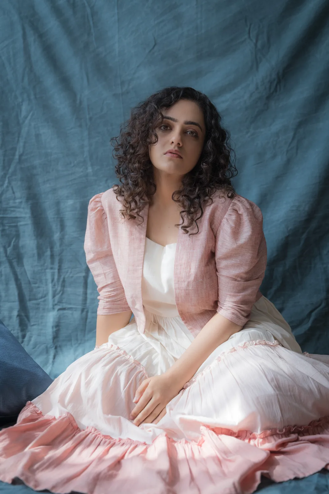 Fashion photograph in a pink dress on a grey draped backdrop, photographed by Shreyak Singh